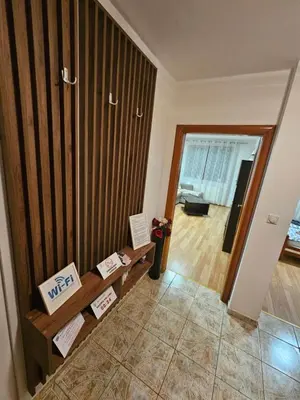 a living room with a wooden wall at Apartman Basic Doboj in Doboj