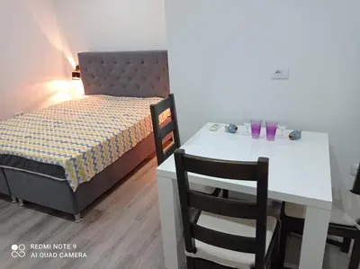 a bedroom with a bed and a white table and chairs at Mars in Banja Luka
