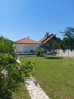a yard with a house and some flowers at Little Aria in Ripač