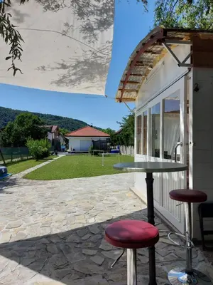 a table and two stools outside of a building at Little Aria in Ripač