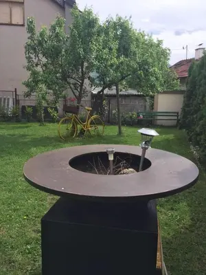 a fountain in the middle of a yard with a bike at Villa Orela Zenica in Zenica