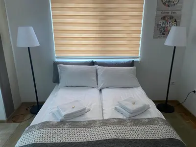 a bed with two white pillows and two lamps at Villa Orela Zenica in Zenica