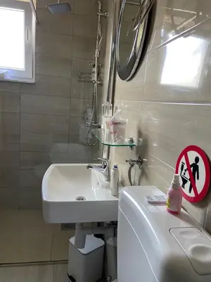 a bathroom with a sink and a toilet and a mirror at Villa Orela Zenica in Zenica