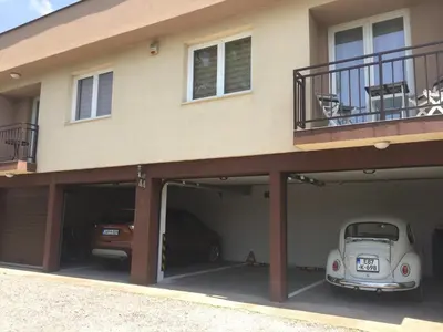 an open garage with a car parked under a house at Villa Orela Zenica in Zenica
