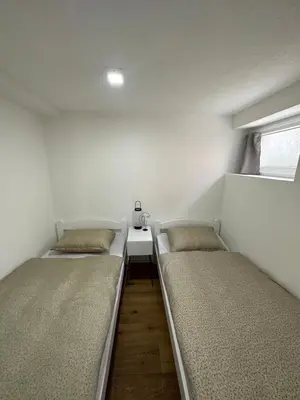two beds in a small room with a table at Lena 2 in Jajce