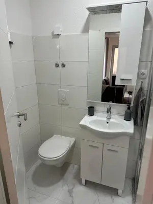 a white bathroom with a toilet and a sink at Lena 2 in Jajce
