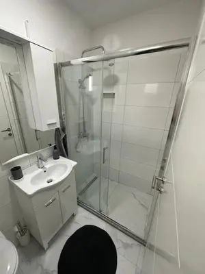 a bathroom with a glass shower and a sink at Lena 2 in Jajce