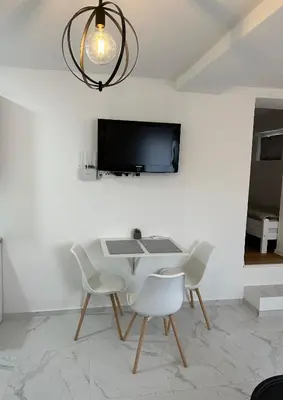 a dining room with a table and two white chairs at Lena 2 in Jajce