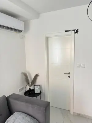 a white door in a room with a gray couch at Lena 2 in Jajce