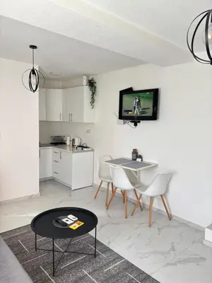 a living room with a table and a tv on the wall at Lena 2 in Jajce
