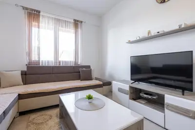 a living room with a couch and a flat screen tv at Apartman Kupres Ski in Kupres
