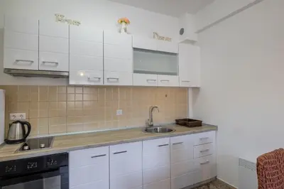 a kitchen with white cabinets and a sink at Apartman Kupres Ski in Kupres