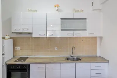 a kitchen with white cabinets and a sink at Apartman Kupres Ski in Kupres