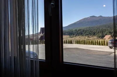 a window with a view of a road and a mountain at Apartman Kupres Ski in Kupres