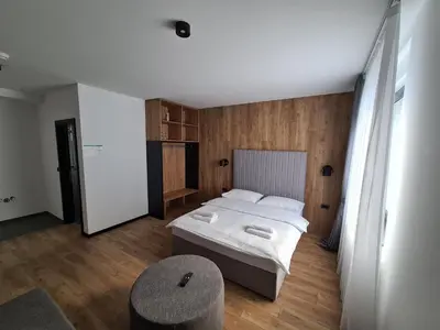 a small bedroom with a bed and a chair at Motel BTG in Tomislavgrad