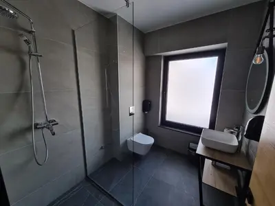 a bathroom with a shower and a toilet and a window at Motel BTG in Tomislavgrad