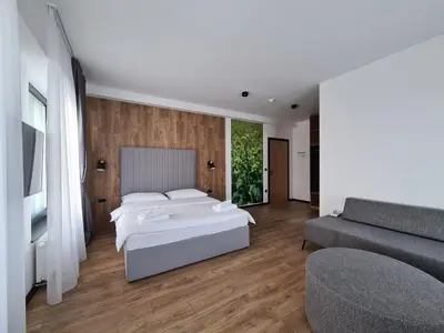 a bedroom with a bed and a couch at Motel BTG in Tomislavgrad