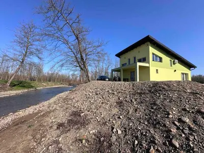 a house on a large pile of dirt next to a road at Beverly Hills SPA Pool House in Donji Podgradci