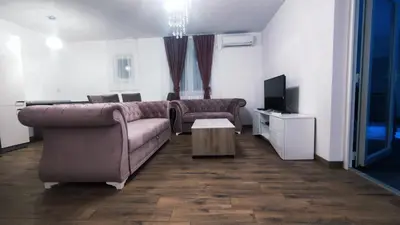 a living room with a couch and a tv at Beverly Hills SPA Pool House in Donji Podgradci