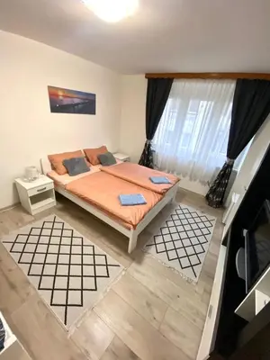a bedroom with a bed and a large window at COZY CENTER Apartment Bihać in Bihać