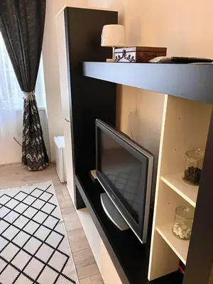 a tv in a shelf with a television at COZY CENTER Apartment Bihać in Bihać