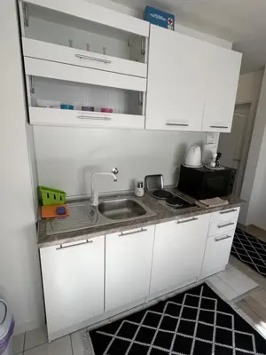 a kitchen with white cabinets and a sink at COZY CENTER Apartment Bihać in Bihać
