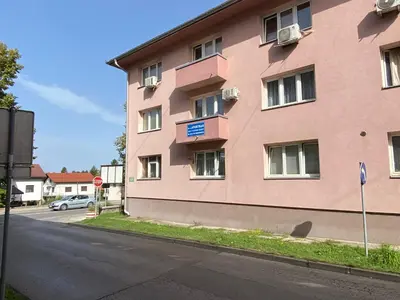 a pink building on the side of a street at COZY CENTER Apartment Bihać in Bihać
