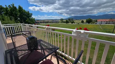 a table on a balcony with a view of a field at Apartment Dolic - Your peaceful spot with a panoramic view in Livno