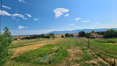 an empty field with a house in the distance at Apartment Dolic - Your peaceful spot with a panoramic view in Livno
