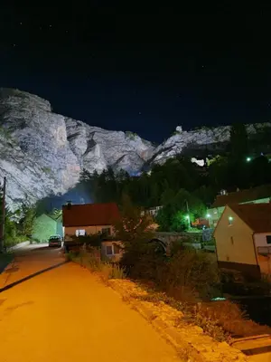 a street at night with a mountain in the background at Apartment Dolic - Your peaceful spot with a panoramic view in Livno