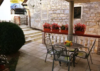 a table and chairs on a patio with flowers at Apartment Dolic - Your peaceful spot with a panoramic view in Livno