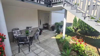 a patio with a table and chairs and flowers at Apartment Dolic - Your peaceful spot with a panoramic view in Livno