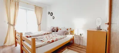 a bedroom with two beds and a large window at MB Deluxe Apartment in Visoko