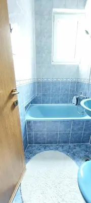 a bathroom with a blue tub and a sink at MB Deluxe Apartment in Visoko
