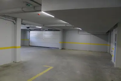 an empty parking garage with white garage doors at VIP Apartment Visoko in Visoko