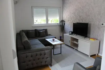 a living room with a couch and a television at VIP Apartment Visoko in Visoko