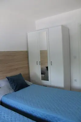 a bedroom with a blue bed and a mirror at VIP Apartment Visoko in Visoko