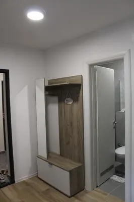 a bathroom with a closet with a wooden door at VIP Apartment Visoko in Visoko