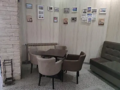 a dining room with a table and chairs and pictures on the wall at Evita Apartmani Šibovska in Prnjavor