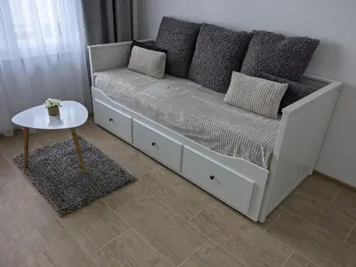 a white bed with pillows and a table in a room at Evita Apartmani Šibovska in Prnjavor