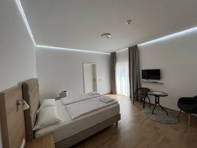 a bedroom with a bed and a desk and a television at Evita Apartmani Šibovska in Prnjavor