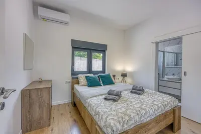 a bedroom with a large bed with blue pillows at Villa Hill with Private Pool in Bosanska Krupa