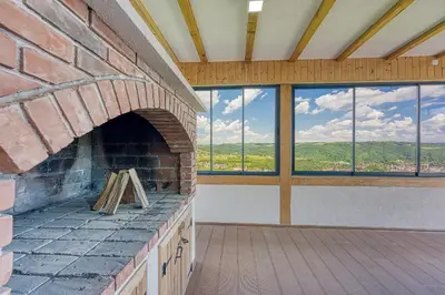 a large brick fireplace in a room with windows at Villa Hill with Private Pool in Bosanska Krupa