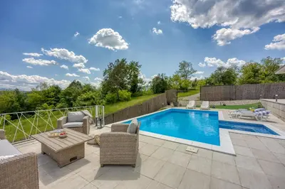 a backyard with a swimming pool and a patio with furniture at Villa Hill with Private Pool in Bosanska Krupa