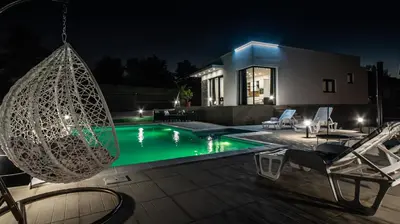 a villa with a swimming pool at night at Villa Hill with Private Pool in Bosanska Krupa