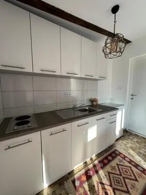 a kitchen with white cabinets and a sink at Perla Accommodation in Visoko