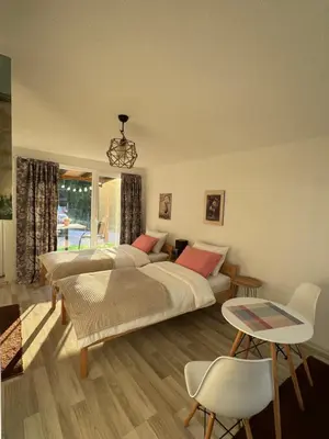 a bedroom with two beds and a table and chairs at Perla Accommodation in Visoko