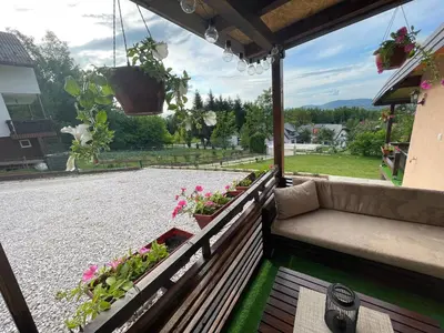 a porch with a couch and flowers on it at Perla Accommodation in Visoko