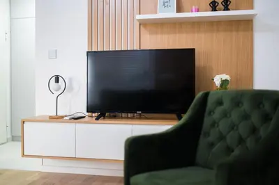a living room with a television on a white cabinet at Liberty Apartments in Tuzla