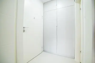 a bathroom with white cabinets and a shower at Liberty Apartments in Tuzla